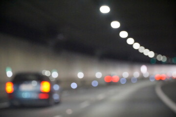 Modern Car Drives Through Tunnel with Bright Lights