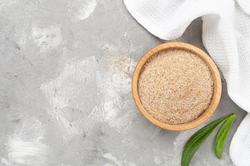 Psyllium husk powder with fresh leaves on concrete background, top view © Liami