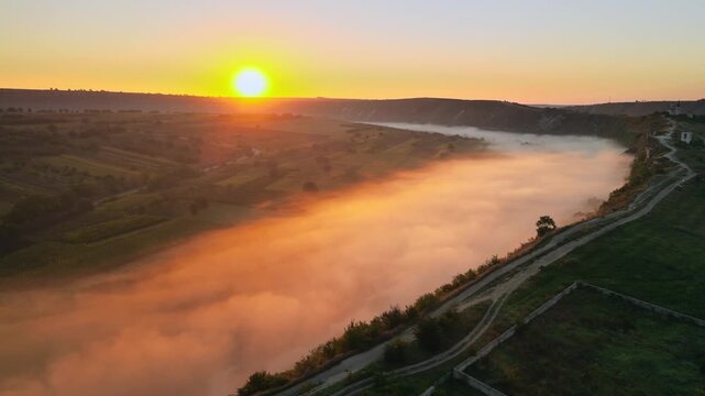 Aerial motion over old orhei monastery, moldova a beautiful view of a misty river with amazing sunrise over natural landscape and historic landmark