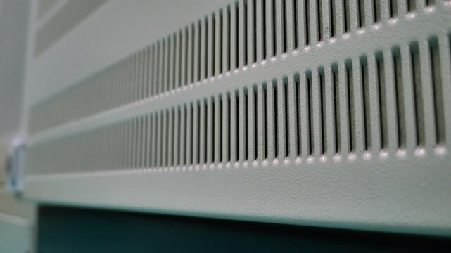 Close-up of a perforated steel cabinet with ventilation holes, representing industrial manufacturing technology, precision engineering, and durable metal fabrication in modern production facilities.