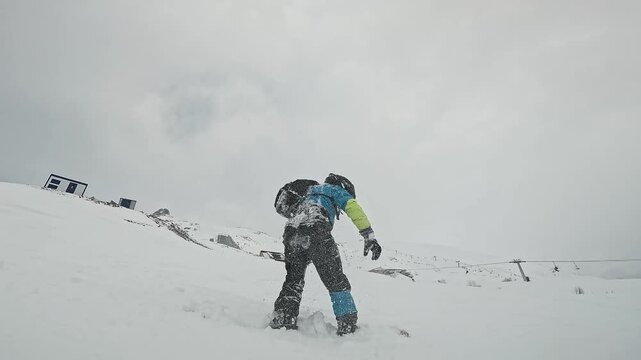 A snowboarder sliding and falling in the snow at a ski resort. Active recreation. Sports equipment. Real people. Lifestyle first-person view. GoPro. Wide Angle