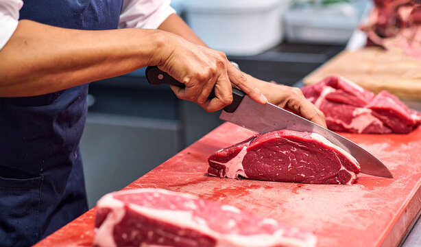 Verkäuferin schneidet frisches Fleisch
