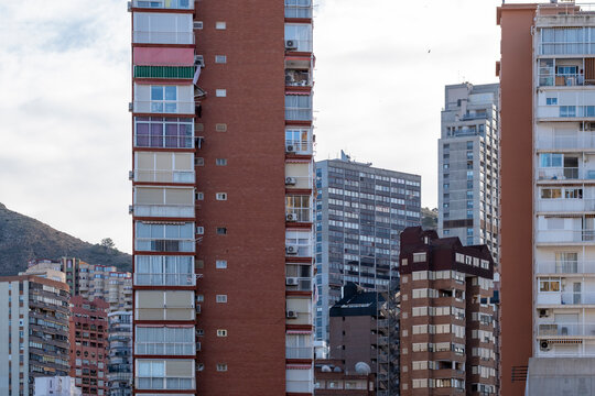 Daylight reveals vertical facade windows on buildings and highrise apartments in urban Benidorm Spain showing dense modern residential geometry