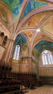 Interior of the Upper Basilica of San Francesco in Assisi featuring medieval frescoes by Giotto, a gothic rose window and starry blue vaulted ceilings, UNESCO site, Umbria, Italy