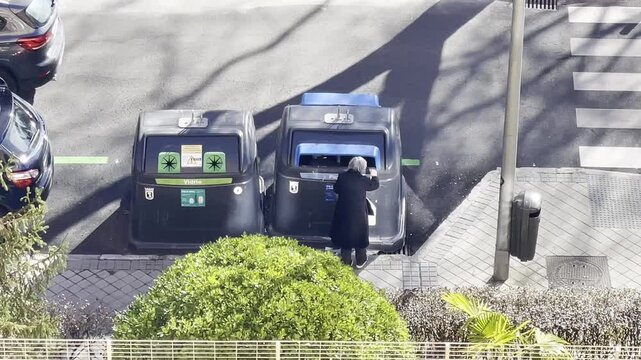 Reciclando basura en contenedor de residuos de vidrio y cart&oacute;n