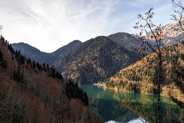 Fototapeta premium Majestic, serene mountain lake with a vibrant mixed evergreen and autumn forest backdrop, ideal for nature travel backgrounds and seasonal themes, showcasing pristine wilderness.