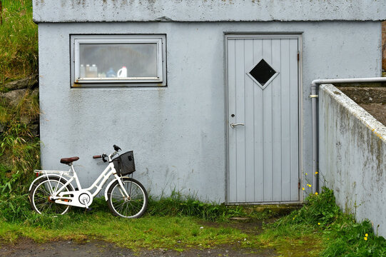 Old white bicycle near the concrete wall,