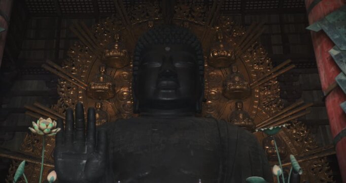 Incense smoke below large, ancient buddha statue - medium shot