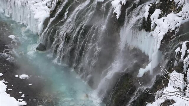 Dramatic View of Shirahige Frozen Waterfall and Mist over Blue Biei River in Winter, Hokkaido