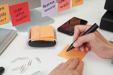 closeup of a man writing a note in an office desk