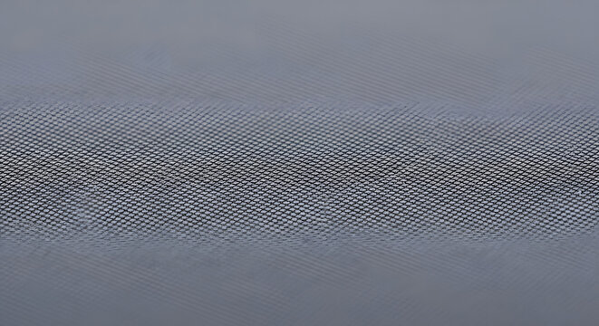 Detailed close-up of a sturdy metallic surface, showcasing a fine, repetitive diamond-cut knurled pattern that provides a robust and textured industrial background