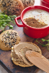 Gourmet Liver Pate Appetizer with Sesame Seed Bagels and and Fresh Pea Shoots on Rustic Wooden Board