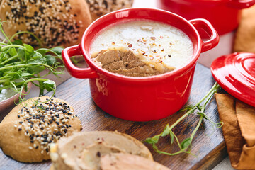 Gourmet Liver Pate Appetizer with Sesame Seed Bagels and and Fresh Pea Shoots on Rustic Wooden Board