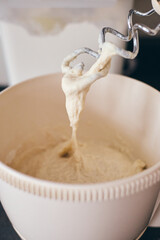 Close-up of stand mixer kneading creamy dough. Smooth texture and mixing process in kitchen setting. Ideal for baking, cooking, culinary content, recipes, food blogs, appliance promotions.