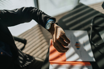 Professional business scene with a suited individual reviewing papers at a sunlit desk.