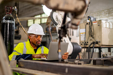 Robotics control engineers setting and maintain spare parts of industrial robot arm controller in production plant factory