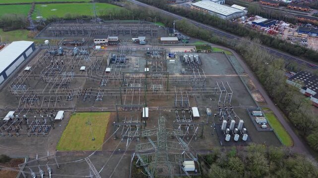 Aerial view of the Enderby Substation National Grid, presenting a network of power lines and electrical equipment against a backdrop of buildings, Enderby, United Kingdom.