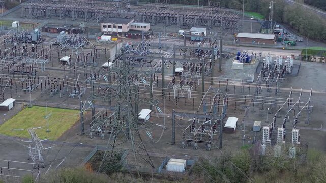 Aerial view of the sprawling Enderby Substation National Grid, a metallic web amidst muted earth tones, showcasing the infrastructure of power, Enderby, United Kingdom.