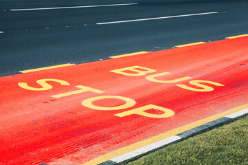 Red bus stop lane painted on the street, providing designated space for public transport and urban mobility infrastructure