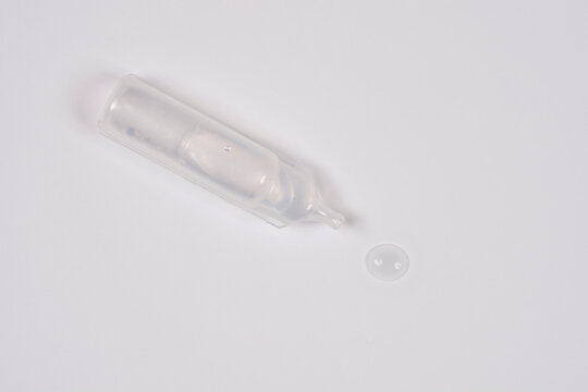 A single use plastic ampoule containing hypertonic sea water solution for nasal or eye care with a small liquid droplet on a white background