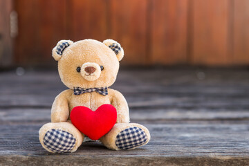 Teddy bear and red heart with space on wood background, valentine concept background idea