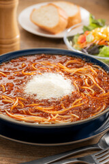 粉チーズをのせたミートソースの大盛りスープパスタ