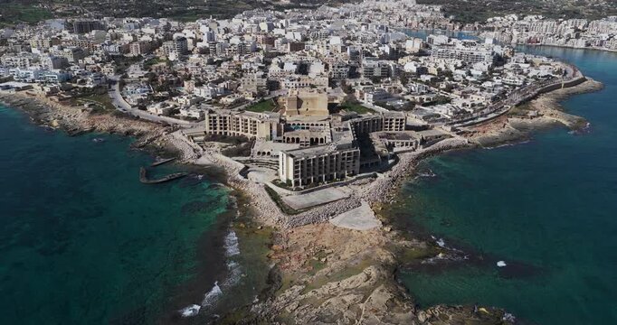 Aerial view of the buildings of Marsaskala by the coast, a contrast of urban development and natural beauty, Marsaskala, Wied il-Ghajn, Malta.