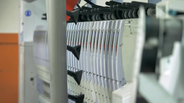 Industrial textile machine processes raw wool fibers during manufacturing. Mechanical rollers and automated systems transform wool material inside a modern textile factory production line.