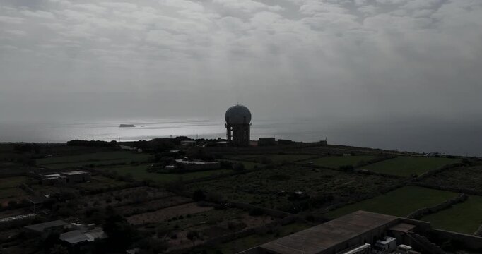 Aerial view of the Dingli Radar, a spherical structure on the coast, surrounded by agricultural fields and the sea, Dingli, Dingli Radar, Malta.