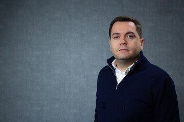 Obraz premium Horizontal studio portrait of a serious man with lateral copy space. Ideal for male issues, mid adult life, and men's health awareness.