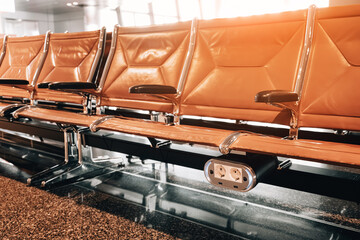 Empty seats with power outlets in an airport waiting area, ready for departure