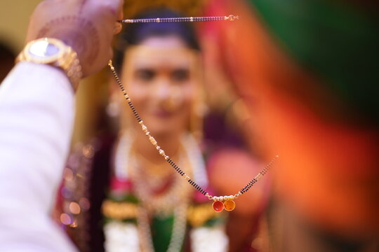 traditional Indian Hindu wedding necklace at a Groom hand in a fream Bride called mangalsutra with Haldi and kumkum. Gold Mangalsutra. Indian Gold Jewellery