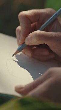 Close-up of sheet where designer drawing a jug with a pencil