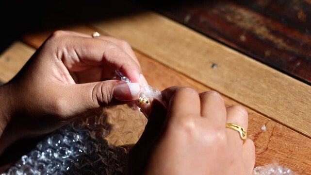 Plastic bubble wrap pressed by hands, sharp popping crackle sounds