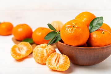 Fresh, ripe, juicy tangerines on the table. Whole and halved tangerines, clementines with green leaves. Citrus fruits. Tangerine or clementine. Fresh oranges. Vitamin C. Natural vitamin. Orange. Space