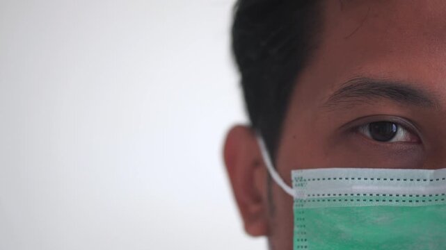 Portrait of man wearing surgical face mask indoors. Male person uses protective accessory during illness and decreased immune system