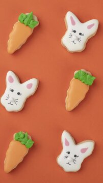 Bunny and carrot easter cookies over orange background