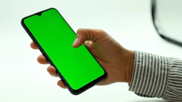 Hand using mobile phone with green screen for advertising or mockup
