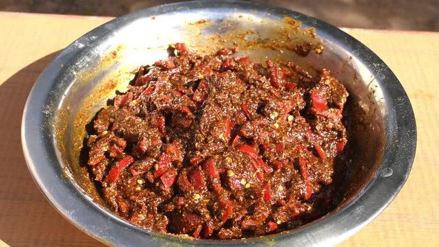 homemade red chilli that is lal mirch ka achar in outside natural sunlight. 