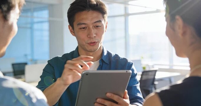 Business professionals collaborate over tablet in modern office setting