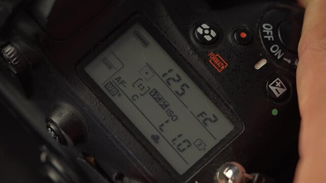 Close-up video of a digital camera LCD screen displaying exposure settings and photographic information. Suitable for concepts related to photography, camera technology, professional equipment, digita