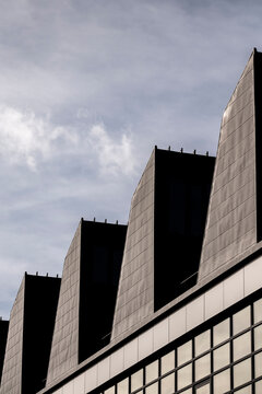 Geometric concrete facade with sharp angles and repeating pattern under open sky creating modern abstract architecture background for design