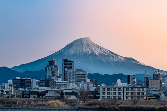 静岡県静岡市の市街地の背後にそびえる富士山と朝焼けのグラデーション
