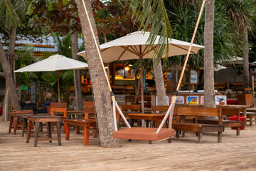 Naklejka premium Tropical Beach Bar with Wooden Swing and Umbrellas in Phu Quoc