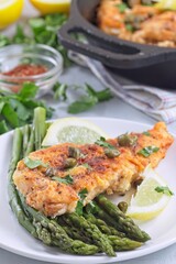 Delicious haddock fish piccata, battered fish fillet with capers, lemon and asparagus, vertical