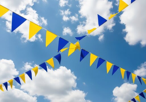 Bright yellow and blue triangular pennant flags strung across a vibrant blue sky filled with fluffy white clouds, creating a festive and celebratory atmosphere