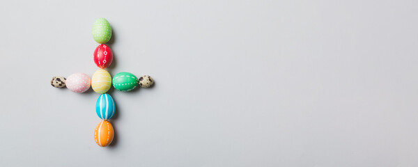 holiday preparation Multi colors Easter eggs on colored background, cross show the religious and secular side of Easter. Pastel color Easter eggs. holiday concept with copy space