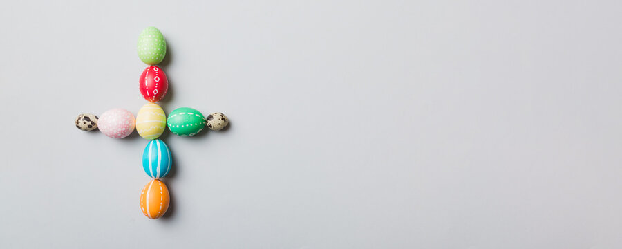 holiday preparation Multi colors Easter eggs on colored background, cross show the religious and secular side of Easter. Pastel color Easter eggs. holiday concept with copy space