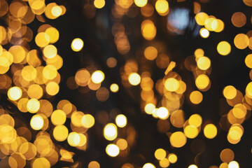 A golden bokeh background featuring soft, small, glowing light orbs in warm tones. The out-of-focus circles create a luminous and celebratory atmosphere. © Ink N Propeller