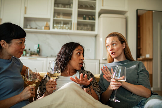 Three women chatting over wine at home